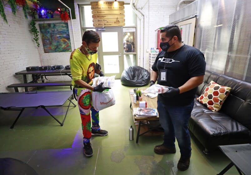 LOS ANGELES, CA - SEPTEMBER 28: Diamond, left, receives healthcare items from Program Manager Christian Diaz at the drop-in center of their location in Skid Row in September of 2021. The Center has a variety of programs for Harm Reduction including needle exchange, work program, and people visiting the space. Center for Harm Reduction on Tuesday, Sept. 28, 2021 in Los Angeles, CA. (Al Seib / Los Angeles Times).