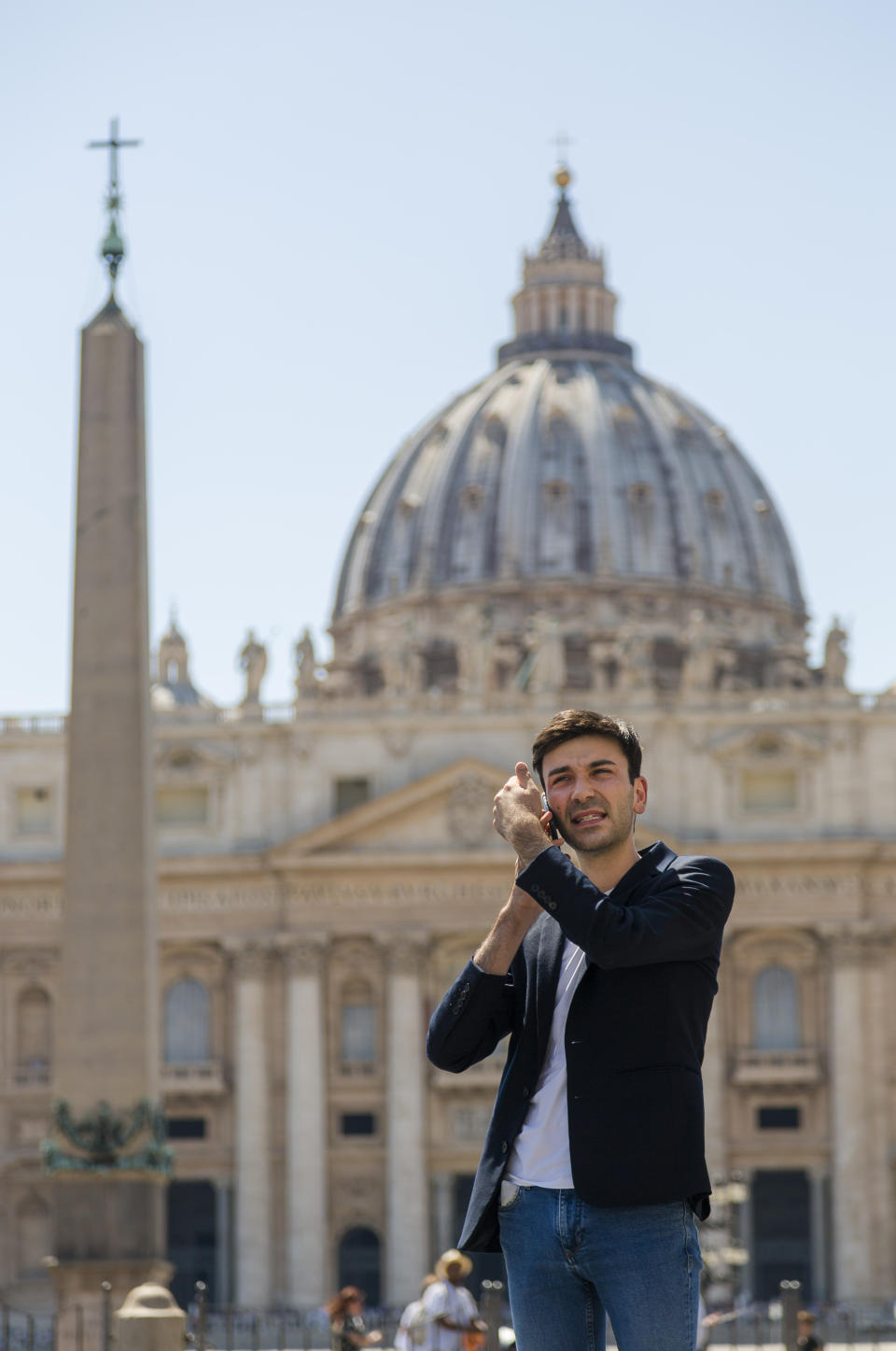 Mathieu De La Souchere speaks on his cellphone after an interview with The Associated Press in St. Peter's Square at The Vatican, Wednesday, July 3, 2019. One of the half-dozen men who have accused the Vatican’s ambassador to France of groping them is taking his complaint directly to the Vatican after claiming the Holy See had invoked diplomatic immunity in a French criminal probe. Mathieu De La Souchere met with one of Pope Francis’ sex abuse advisers on Wednesday after filing a police report in Paris earlier this year. (AP Photo/Domenico Stinellis)