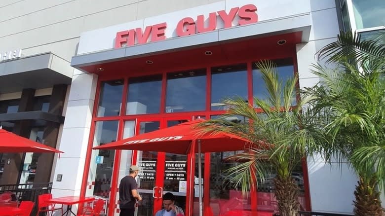 outside of a Five Guys with palm trees