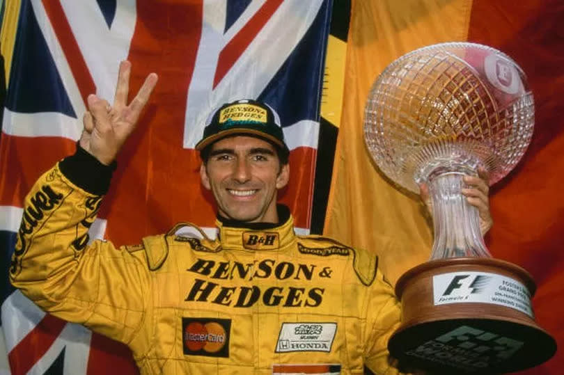 Damon Hill celebrates with the trophy after winning the Formula One Belgian Grand Prix in August 1998