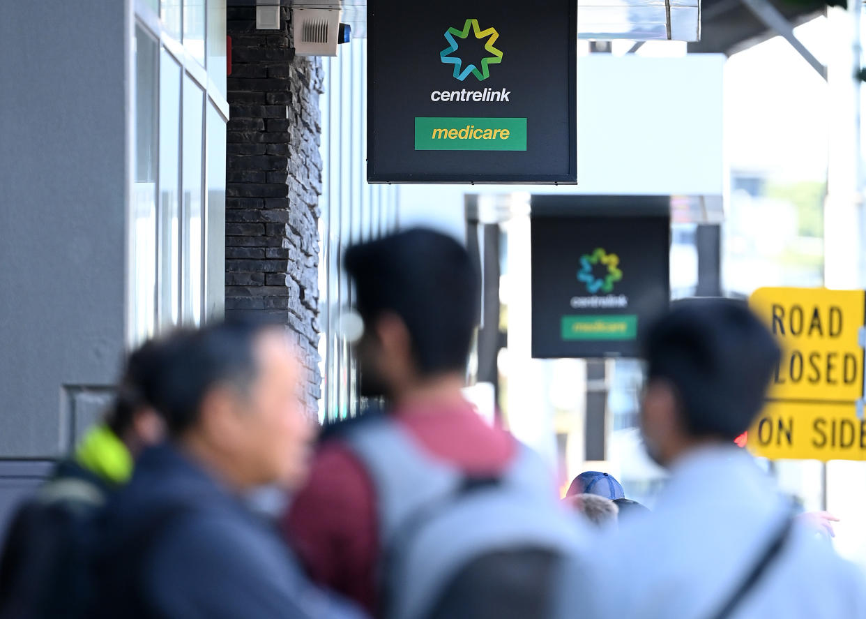 MELBOURNE, AUSTRALIA - MARCH 24: Peopler queue to enter Centrelink on March 24, 2020 in Melbourne, Australia. Non-essential travel has been banned in a bid to stop the spread of COVID-19 in Australia while venues such as bars, clubs, nightclubs, cinemas, gyms and restaurants, along with anywhere people remain static are now closed. Schools are currently open but parents have the option to keep children at home if they wish. There are now 1887 confirmed cases of COVID-19 in Australia and the death toll now stands at eight. (Photo by Quinn Rooney/Getty Images)