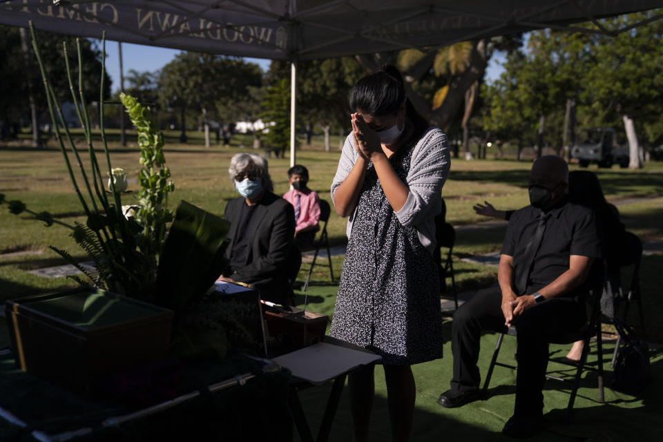 Lilah Matsumura, 11, prays for for her great-grandfather, Giichi Matsumura, during a memorial service at Woodlawn Cemetery in Santa Monica, Calif., Monday, Dec. 21, 2020. Giichi Matsumura, who died in the Sierra Nevada on a fishing trip while he was at the Japanese internment camp at Manzanar, was reburied in the same plot with his wife 75 years later after his remains were unearthed from a mountainside grave. (AP Photo/Jae C. Hong)