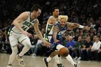 Milwaukee Bucks' Pat Connaughton and Charlotte Hornets' Kelly Oubre Jr. go after a loose ball during the first half of an NBA basketball game Wednesday, Dec. 1, 2021, in Milwaukee. (AP Photo/Morry Gash)