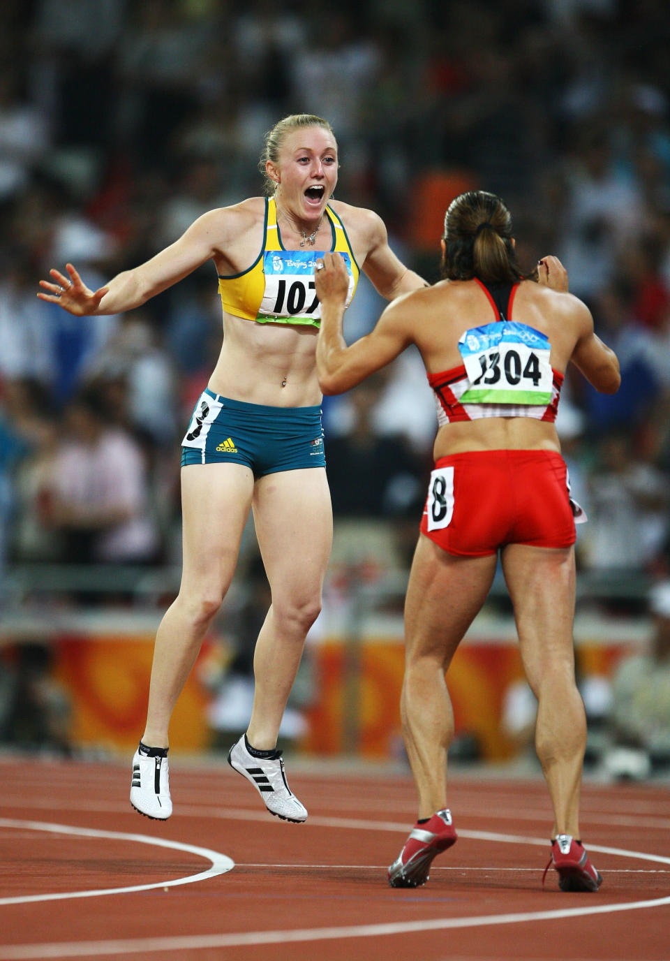 BEIJING - AUGUST 19: Priscilla Lopes-Schliep of Canada celebrates third place and Sally McLellan of Australia celebrates second place in the Women's 100m Hurdles Final held at the National Stadium on Day 11 of the Beijing 2008 Olympic Games on August 19, 2008 in Beijing, China. (Photo by Jeff Gross/Getty Images)