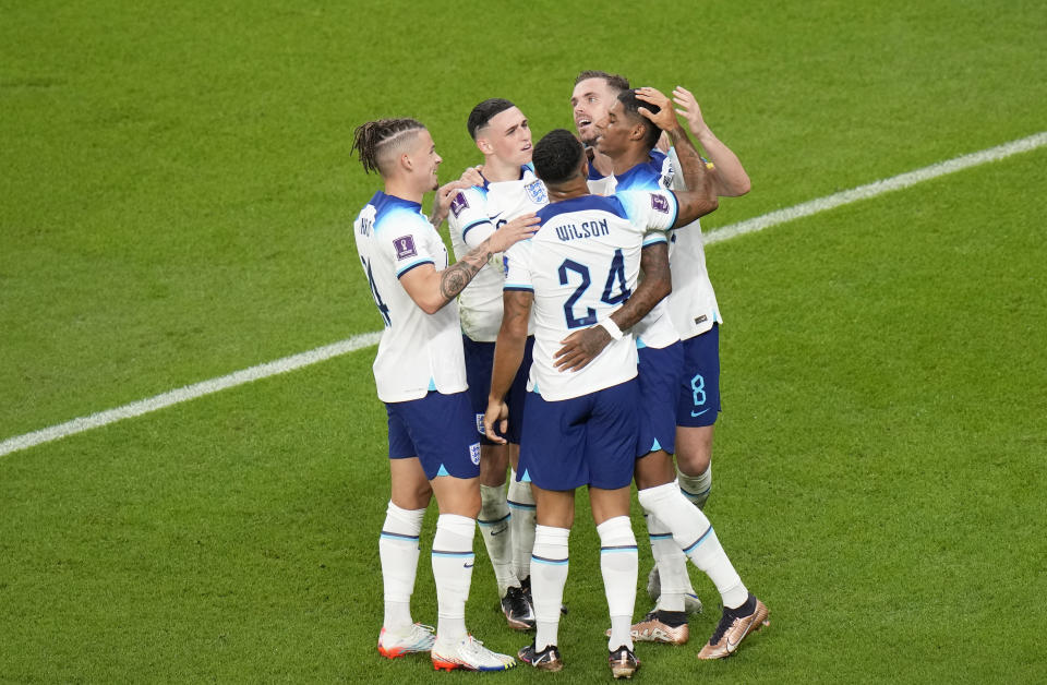 England's Marcus Rashford, right, celebrates with teammates after scoring his side's third goal during the World Cup group B soccer match between England and Wales, at the Ahmad Bin Ali Stadium in Al Rayyan , Qatar, Tuesday, Nov. 29, 2022. (AP Photo/Alessandra Tarantino)