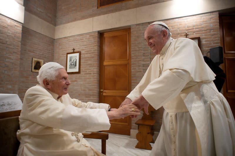 FILE PHOTO: Pope Francis and Pope Emeritus Benedict XVI meet with new cardinals at the Vatican