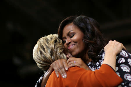 First lady Michelle Obama embraces Hillary Clinton as they arrive at a campaign rally in Winston-Salem, North Carolina. REUTERS/Carlos Barria