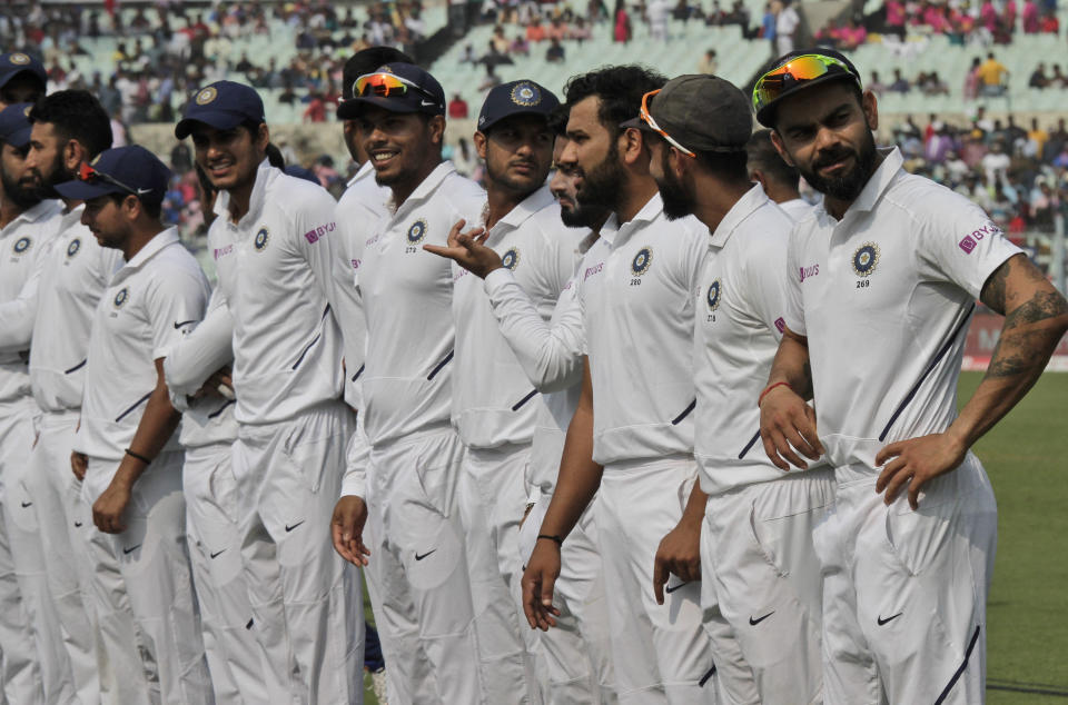 Indian cricket captain Virat Kohli, right, stands with teammates during the first day of the second test match against Bangladesh in Kolkata, India, Friday, Nov. 22, 2019. India and Bangladesh are playing their first day-night test match with a pink ball. (AP Photo/Bikas Das)