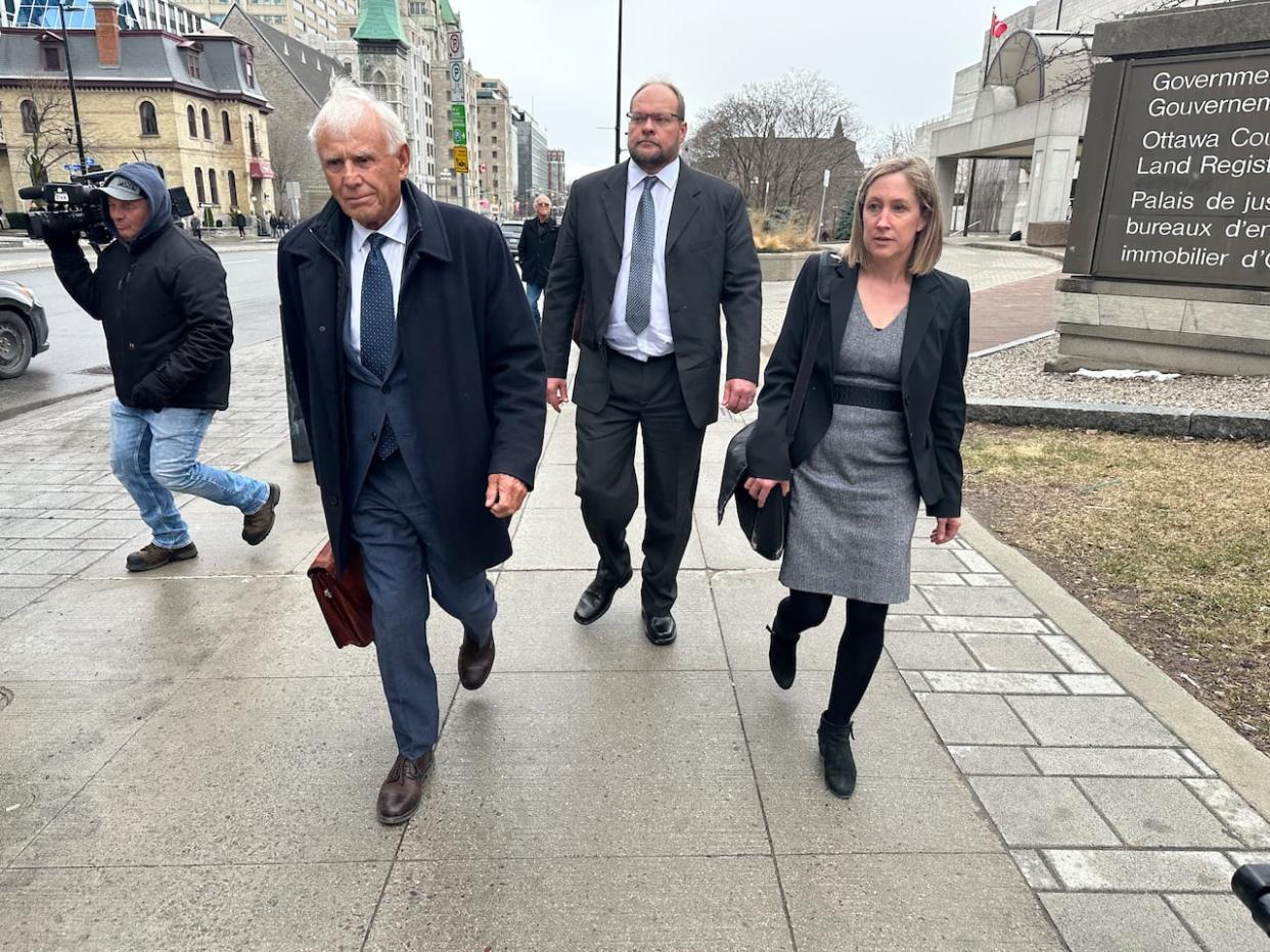 Eastway Tank, Pump and Meter owner Neil Greene, centre, leaves the Ottawa courthouse with his defence lawyers on Friday. (Guy Quenneville/CBC - image credit)