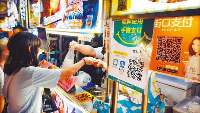 寧夏夜市許多攤商都接受「街口支付」、「支付寶」等行動支付方式。（姚志平攝）