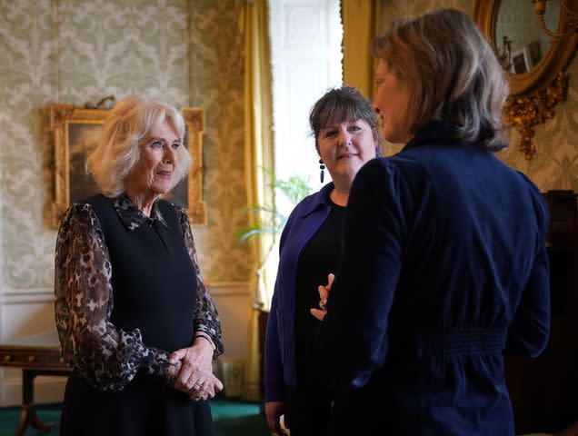 <p>Yui Mok-WPA Pool/Getty</p> Queen Camilla (left) speaks with Chief Executive SafeLives Ellen Miller (C) and Chair of Trustees SafeLives Isabel Boyer during a reception at Buckingham Palace on April 16, 2024.