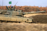 A Japanese Ground-Self Defense Force (JGDDF) Type 90 tank maneuvers through a course during an annual exercise at the Minami Eniwa Camp Tuesday, Dec. 7, 2021, in Eniwa, Japan's northern island of Hokkaido. Dozens of tanks are rolling over the next two weeks on Hokkaido, a main military stronghold for a country with perhaps the world's most little known yet powerful army. (AP Photo/Eugene Hoshiko)