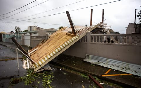 The wreckage of a pergola is pictured in the village of Goyave - Credit: CEDRICK ISHAM CALVADOS/AFP