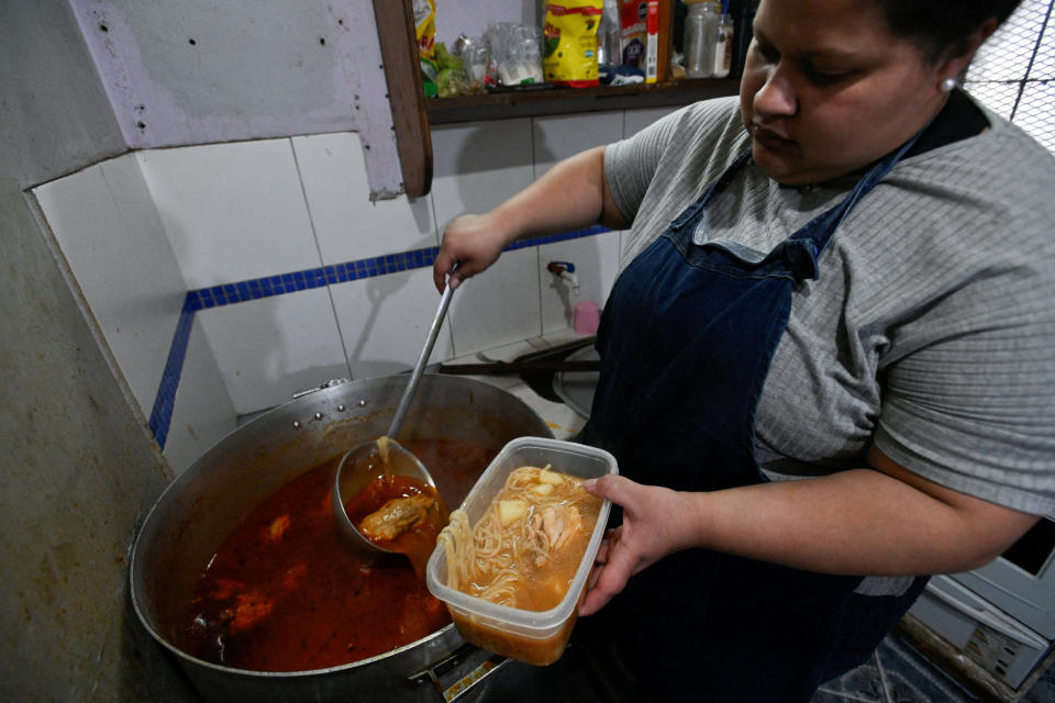 Betiana Juárez, de 27 años, quien ayuda en un comedor de beneficencia como cocinera voluntaria, sirve una ración de guiso en un recipiente de plástico antes de dárselo a una familia, en Villa Soldati, en las afueras de Buenos Aires, Argentina, el 10 de septiembre de 2024. REUTERS/Mariana Nedelcu/Foto de archivo