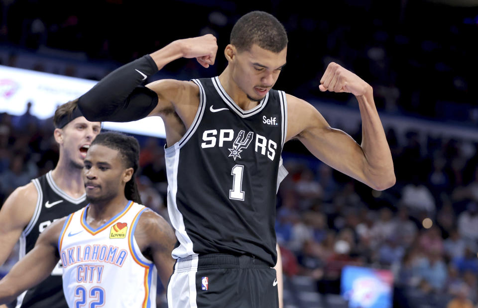 San Antonio Spurs center Victor Wembanyama (1) celebrates after a basket in front of Oklahoma City Thunder guard Cason Wallace (22) in the first half of a preseason NBA basketball game, Monday, Oct. 9, 2023, in Oklahoma City. (AP Photo/Sarah Phipps)