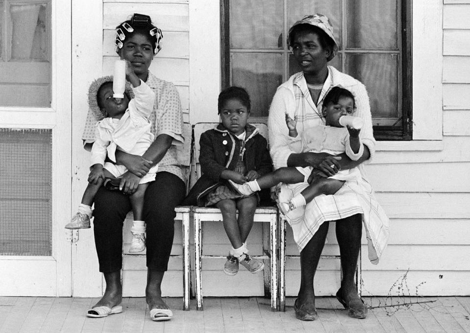 Two mothers with children watching marchers, 1965.