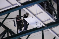 American Airlines Center workers set up a barrier to help prevent rain from falling onto the basketball court during the second half of Game 4 of the NBA basketball playoffs Western Conference finals between the Dallas Mavericks and the Golden State Warriors, Tuesday, May 24, 2022, in Dallas. (AP Photo/Tony Gutierrez)