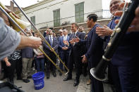 French President Emmanuel Macron claps to the performance of a street band as he walks down Royal St. in the French Quarter of New Orleans, Friday, Dec. 2, 2022. Right is New Orleans Mayor Latoya Cantrell. (AP Photo/Gerald Herbert)