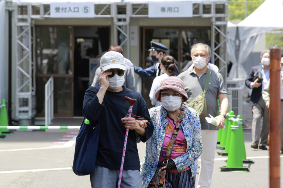 Elderly people go out of the newly-opened mass vaccination center after receiving the Moderna coronavirus vaccine in Tokyo, Monday, May 24, 2021. Japan mobilized military doctors and nurses to give shots to elderly people in Tokyo and Osaka on Monday as the government desperately tries to accelerate its vaccination rollout and curb coronavirus infections just two months before hosting the Olympics. (AP Photo/Koji Sasahara)