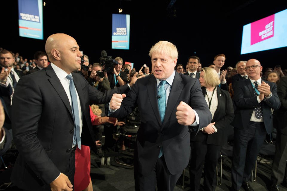 Prime Minister Boris Johnson (centre) is given a pat on the back by Chancellor of the Exchequer Sajid Javid, as he leaves the stage after delivering his speech during the Conservative Party Conference at the Manchester Convention Centre. (Photo by Stefan Rousseau/PA Images via Getty Images)