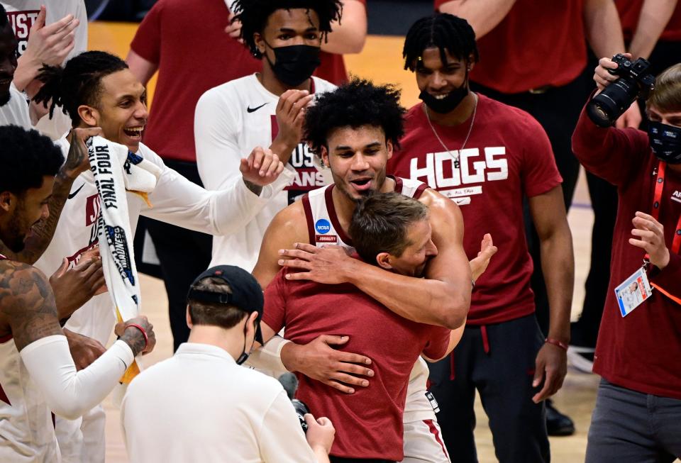 Justin Smith embraces coach Eric Musselman after Arkansas defeated Texas Tech in the second round of the 2021 NCAA Tournament at Hinkle Fieldhouse.