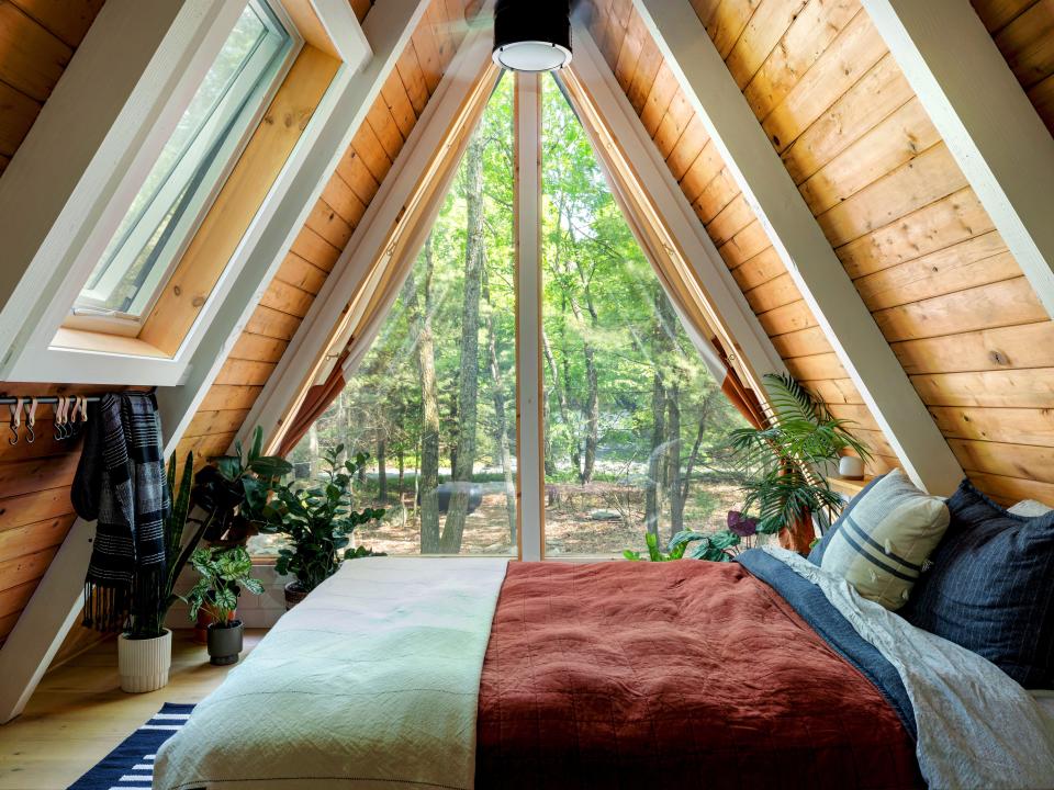 The A-frame cabin has a loft where the bedroom is situated.