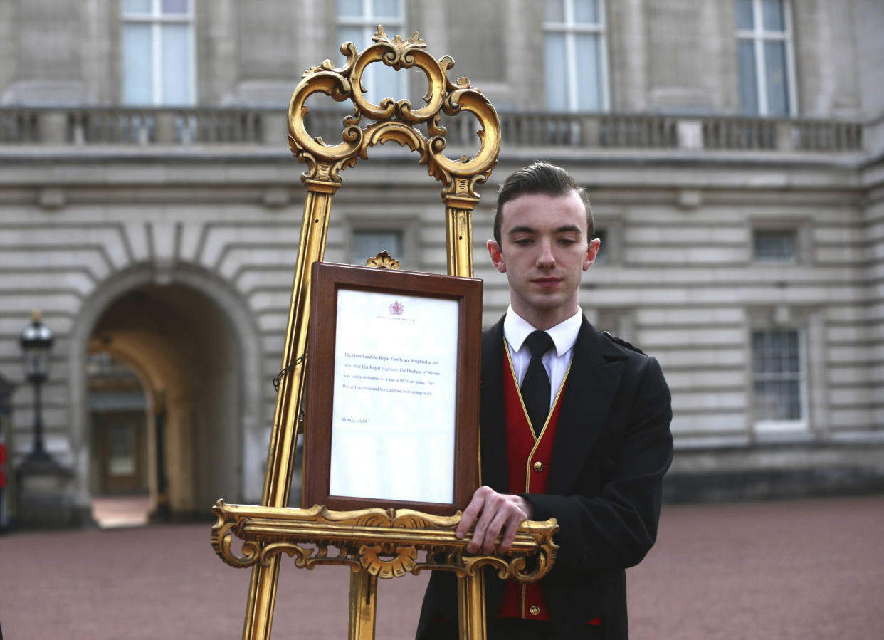 Footmen Stephen Kelly brings out the easel in the forecourt of Buckingham Palace to formally announce the birth of a baby boy to  Britain's Prince Harry and Meghan, the Duchess of Sussex, in London, Monday, May 6, 2019. (Yui Mok/Pool Photo via AP)