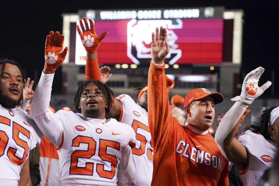 Clemson coach Dabo Swinney sings the school alma mater with safety Jalyn Phillips (25) after the team's NCAA college football game against South Carolina on Saturday, Nov. 27, 2021, in Columbia, S.C. Clemson won 30-0. (AP Photo/Sean Rayford)