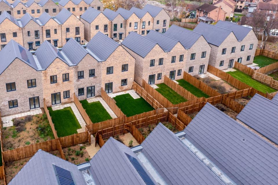 aerial view of residential neighborhood with solar panels on roofs and green lawns