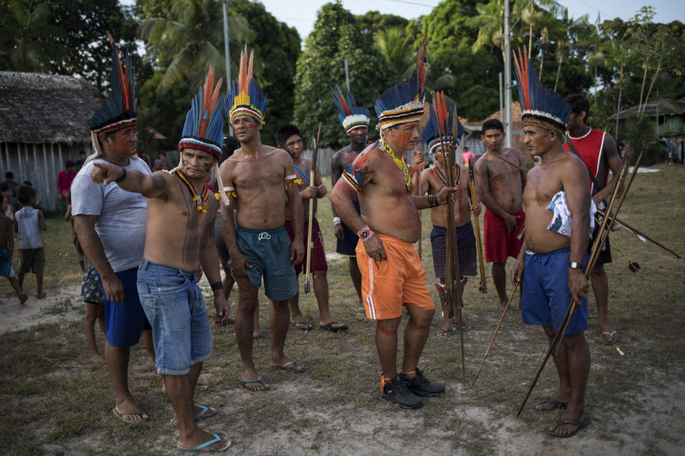 In this Sept. 3, 2019 photo, indigenous leaders gather to talk during a meeting of Tembé tribes in Tekohaw indigenous reserve, Para state, Brazil. Some saw hope in the sustainable development plan presented this week at the meeting in the village of Tekohaw. It would include drones and other technology to curb the encroachers while helping the Tembe profit by harvesting wood, bananas and acai berries in a limited way from a part of their jungle _ hopefully no faster than the jungle replenishes itself. (AP Photo/Rodrigo Abd)