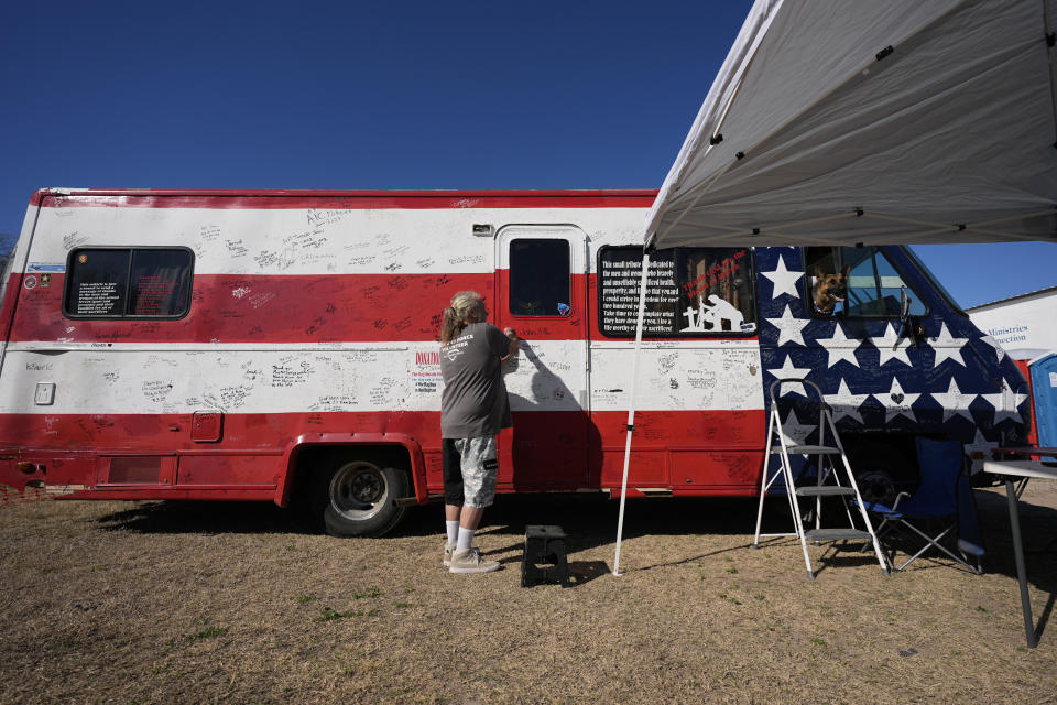 Irvin Russell Pelton Jr., with his dog Stars, right, prepares to offer free haircuts during a "Take Our Border Back" convoy and rally, Saturday, Feb. 3, 2024, in Quemado, Texas. (AP Photo/Eric Gay)