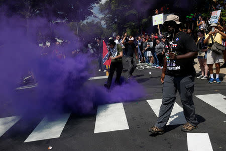 A smoke bomb is thrown at a group of counter-protesters during a clash against members of white nationalist protesters in Charlottesville, Virginia, U.S., August 12, 2017. REUTERS/Joshua Roberts