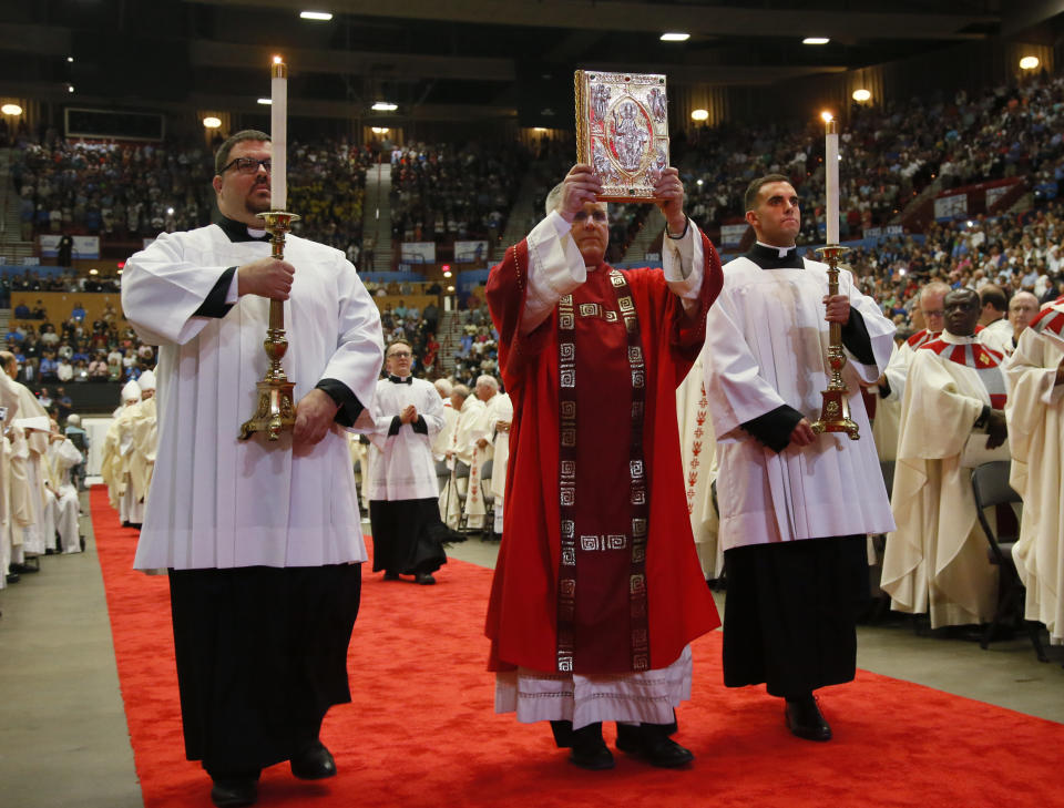 FILE - The book of gospels is carried in a processional before the Mass during the Beatification Ceremony for Stanley Rother in Oklahoma City, Saturday, Sept. 23, 2017. The 46-year-old priest, shot to death in 1981, became the Catholic Church’s first martyr to be born in the United States. Now a $50 million shrine built to honor the slain missionary — killed by three masked assassins who entered his rectory during Guatemala’s civil war — is expected to draw thousands of pilgrims to his home state. (AP Photo/Sue Ogrocki, File)