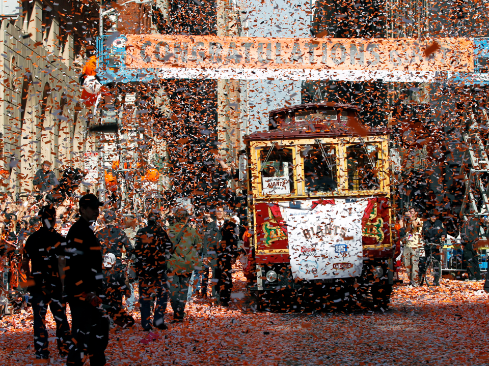 A cable car replica tour bus transports San Francisco Giants players through a sea of confetti during a victory parade for the World Series champions in San Francisco.