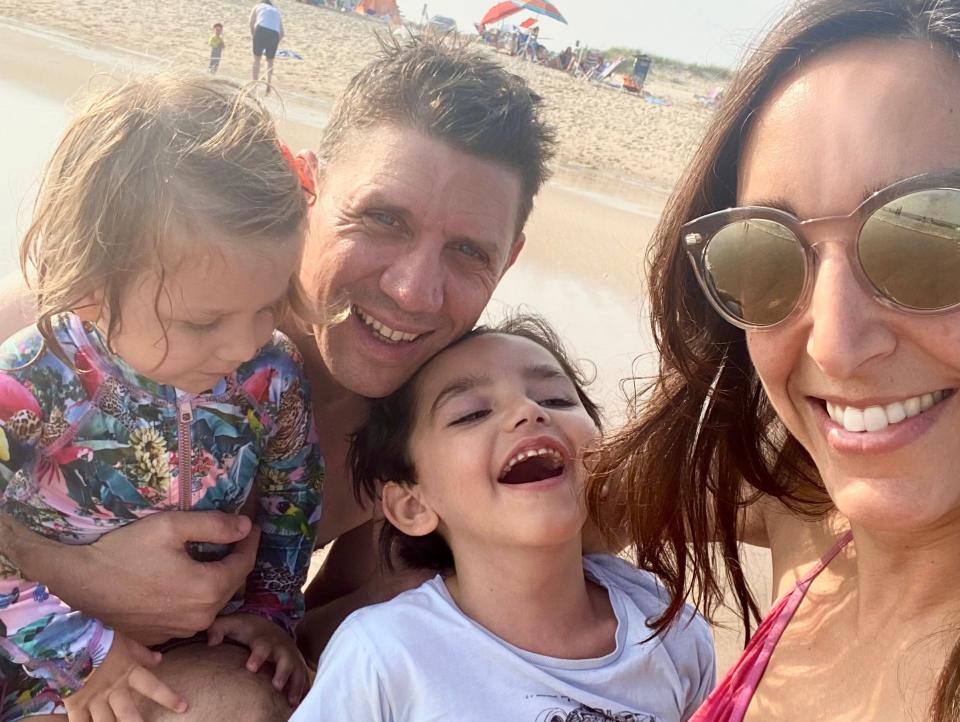 The Vauclare family pose in their swimsuits for a selfie on a beach