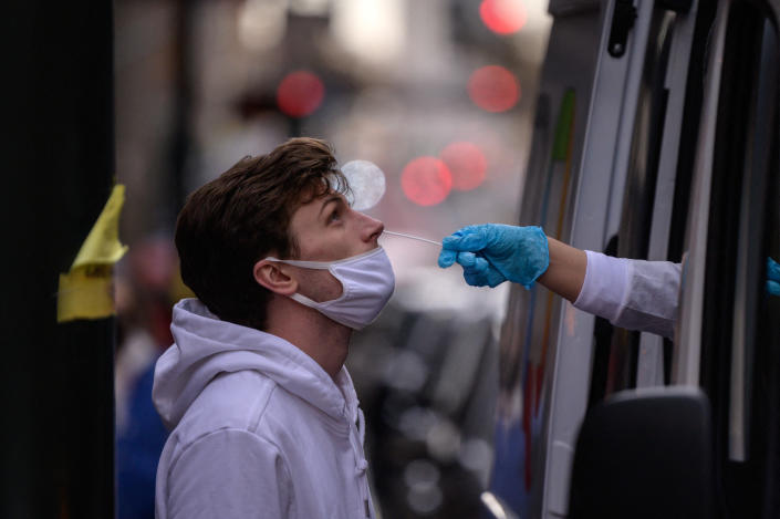 A man has a nasal swab test for COVID at a streetside testing booth in New York in December 2021. 