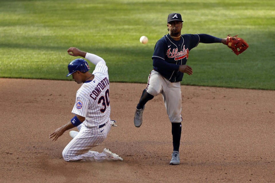 Atlanta Braves second baseman Ozzie Albies turns a double play against New York Mets' Michael Conforto (30) during the seventh inning of a baseball game Saturday, July 25, 2020, in New York. (AP Photo/Adam Hunger)
