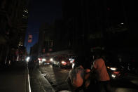 A man makes his way through a dark Times Square during a power outage, Saturday, July 13, 2019, in New York. Authorities were scrambling to restore electricity to Manhattan following a power outage that knocked out Times Square's towering electronic screens and darkened marquees in the theater district and left businesses without electricity, elevators stuck and subway cars stalled. (AP Photo/Michael Owens)