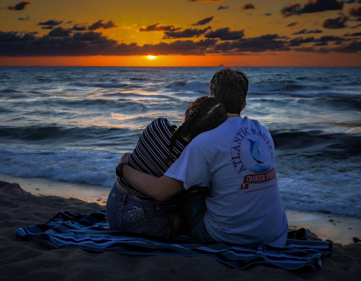 A couple hugs while taking in the sunrise at Midtown Beach on June 22. According to a community survey conducted over the summer, Palm Beachers are overwhelmingly satisfied with the quality of life in their town.