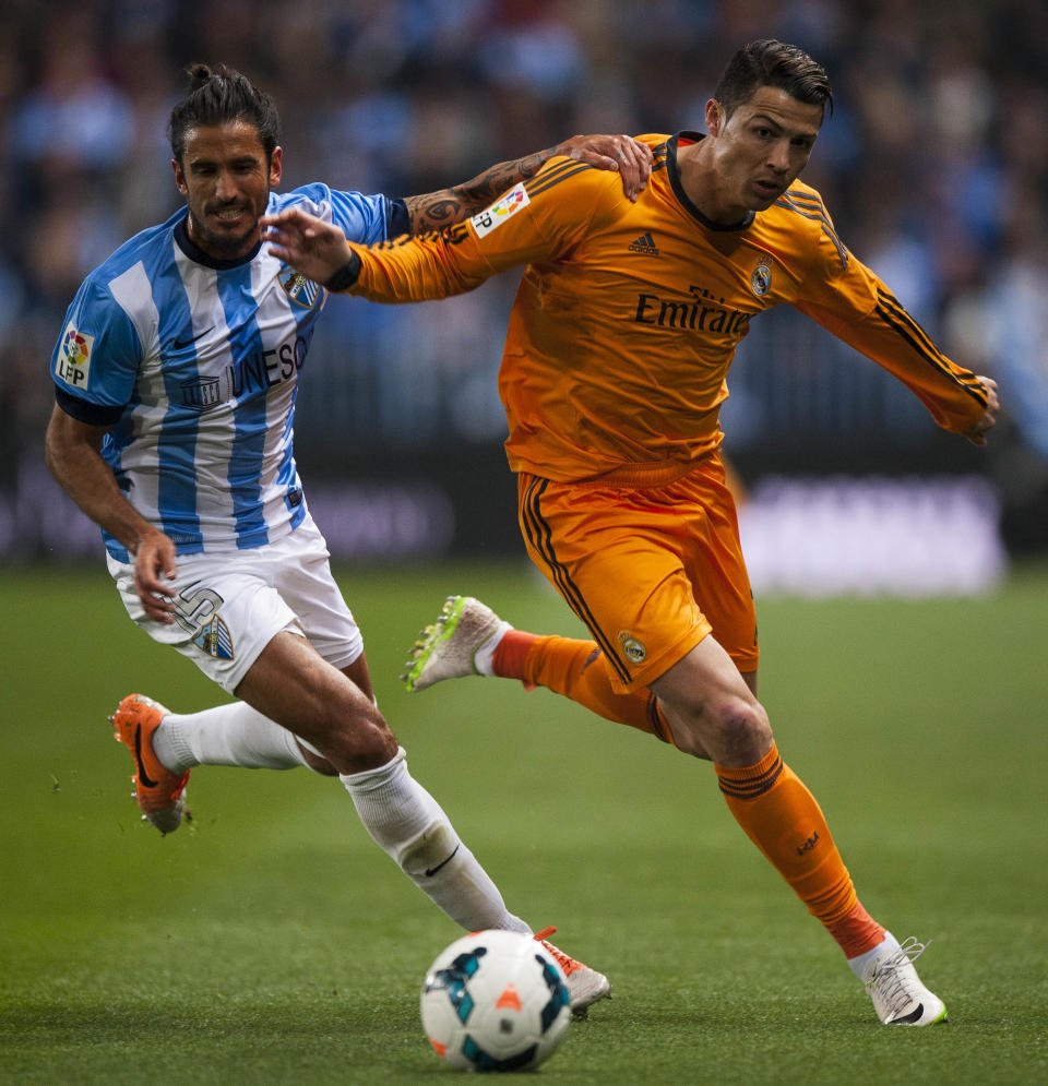 Real Madrid's Cristiano Ronaldo, right, duels for the ball against CF Malaga's Marcos Alberto Angeleri, left, during a Spanish La Liga soccer match at La Rosaleda stadium in Malaga, Spain, Saturday March 15, 2014. (AP Photo/Daniel Tejedor)