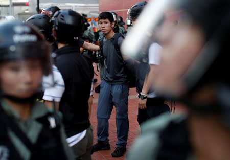 An anti-government protester is detained during a march in Tuen Mun, Hong Kong