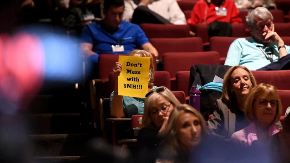 A person holds up a sign in the auditorium Monday where dozens of “medical freedom” activists attended a public board meeting at Sarasota Memorial Hospital, criticizing the hospital’s response to the COVID-19 pandemic and suggested alternative methods.