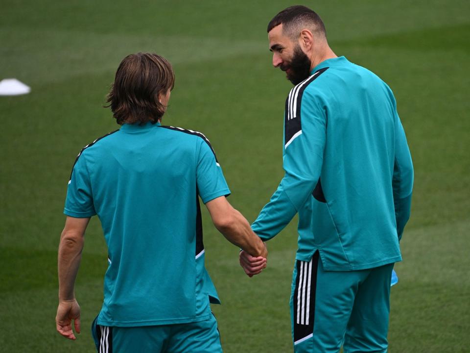 Real Madrid’s French forward Karim Benzema and the Croatian midfielder Luka Modric hold hands during a training session in May (Getty Images)