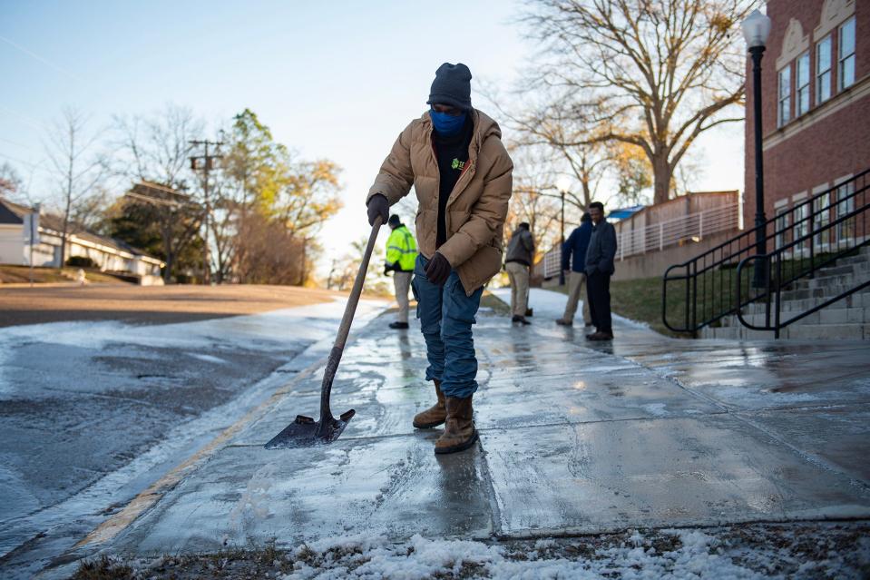 Reginald Issac, SEJ Services employee, scrapes ice off the sidewalk at First Presbyterian Church before kids arrive for school in Jackson, Miss., on Wednesday, Jan. 17, 2024.