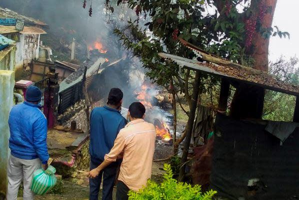 Local residents try to contain the fire after a helicopter carrying India's Chief of Defense Staff General Bipin Rawat crashed  near Coonoor, Tamil Nadu state,  India, December 8, 2021. / Credit: Bangalore New Photos via AP