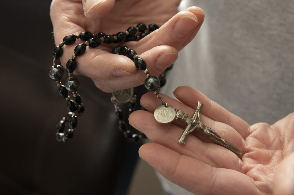 Tim Lillard holds a rosary with his late wife's name on it. It was given to him as a gift after her death in 2022. Over the past year, Lillard has become an advocate for legislation to limit the number of patients in a nurse's care. (Beth Weiler/Michigan Public)