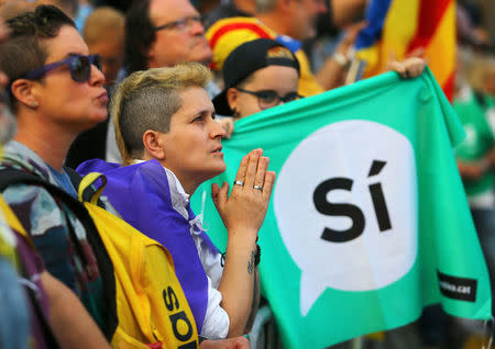 People react as they watch a session of the Catalonian regional parliament on a giant screen at a pro-independence rally in Barcelona, Spain, October 10, 2017. REUTERS/Ivan Alvarado