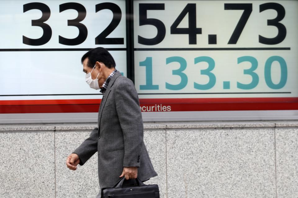 A person walks in front of an electronic stock board showing Japan's Nikkei 225 index at a securities firm Tuesday, Nov. 21, 2023, in Tokyo. Asian shares were mostly higher on Tuesday after a rally on Wall Street led by gains in Microsoft following its announcement that it was hiring Sam Altman, former CEO of OpenAI, the ChatGPT maker. (AP Photo/Eugene Hoshiko)