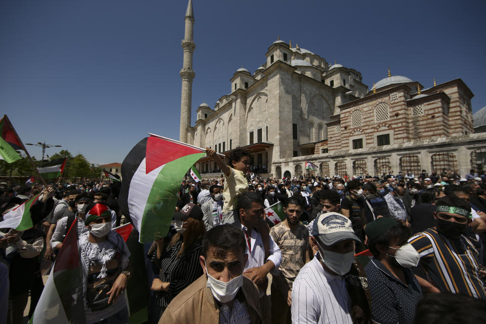 A child holds a Palestinian flag during a rally outside Fatih mosque in Istanbul following Friday prayers, Friday, May 4, 2021, in support of Palestinians, killed in the recent escalation of violence in Jerusalem and the Gaza Strip. People in Turkey have been demonstrating against Israel this week and have gathered without much interference from the police despite a strict lockdown to curb COVID-19 infections that have ordered people to stay home until May 17.(AP Photo/Emrah Gurel)