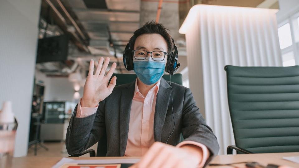 an asian chinese mid adult white collar worker talking to the camera video calling video conference with his business partners.